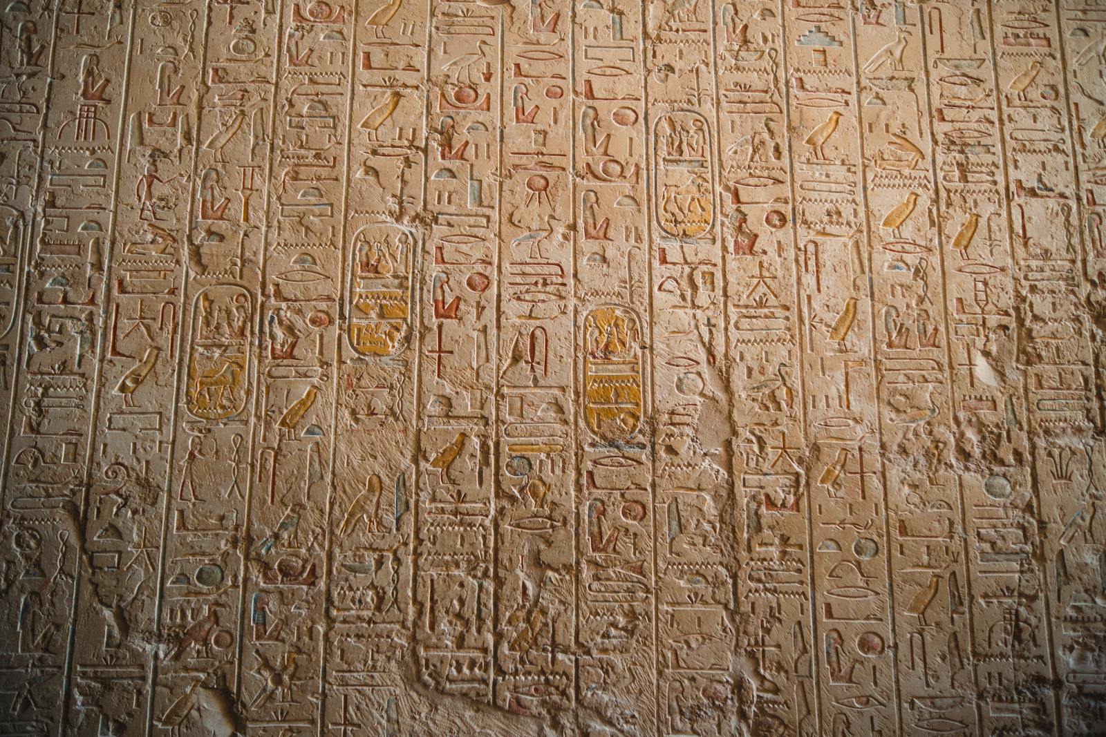 Parois couvertes de hiéroglyphes gravés, l'écriture que la pierre de Rosette a permis de lire